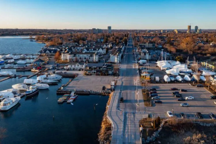 pickering ontario Aerial view of a marina with boats, a road, and a town in the distance under a clear sky 